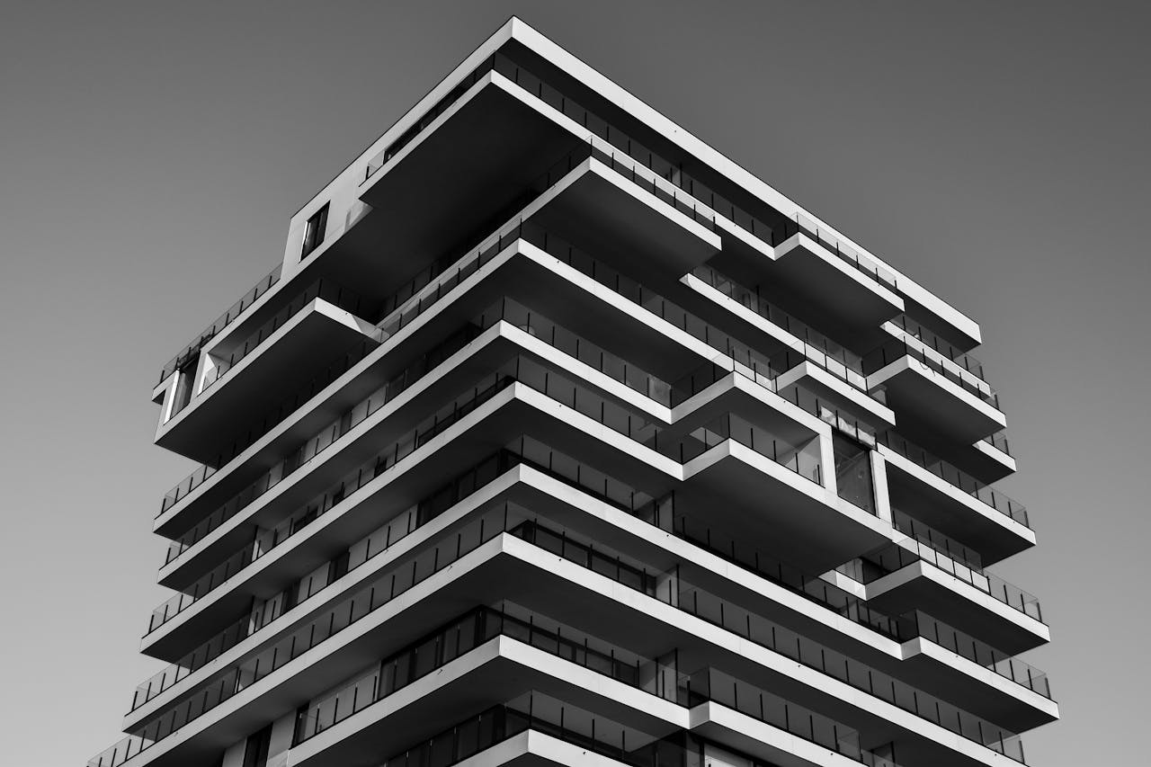 services-02 A striking black and white photo of a modern high-rise building with unique geometric designs.