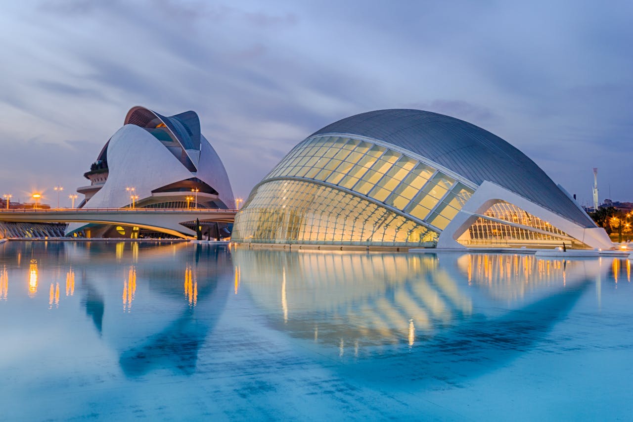 services-01 A breathtaking view of Valencia's City of Arts and Sciences reflected in serene waters at twilight.